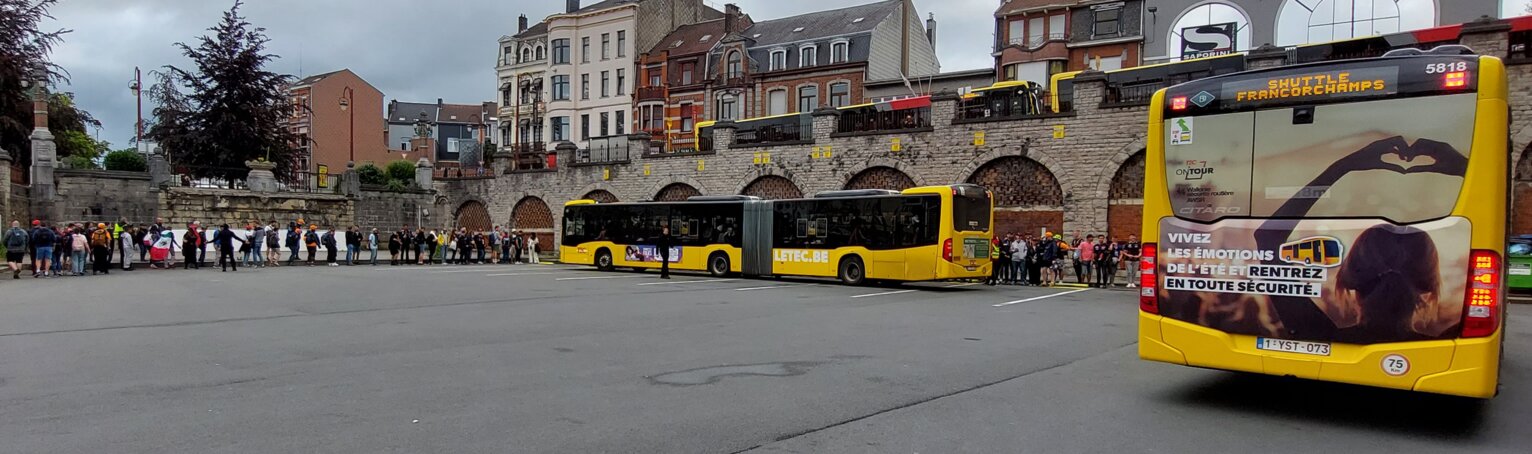 The bus station on race day. Two busses are ready to pick up the queueing people.